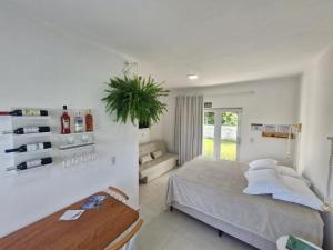a bedroom with a bed and a potted plant at Palo Santo - Praia do Rosa in Praia do Rosa