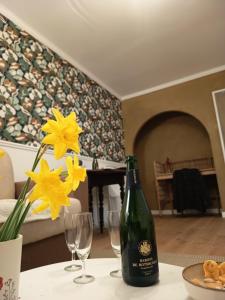 a bottle of wine sitting on a table with yellow flowers at Appartement cosy Nantes proche gare in Nantes +15 photos