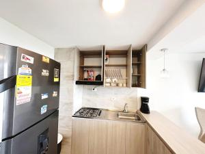 a small kitchen with a sink and a refrigerator at Wow que vista!! Frente Ecoparque 7min CC Buenavista in Puerto Colombia