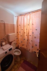 a bathroom with a toilet and a shower curtain at Vila AT in Sarajevo +6 photos