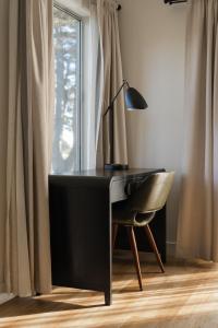 uma secretária com um candeeiro e uma cadeira ao lado de uma janela em Bodega Coast Inn and Suites em Bodega Bay