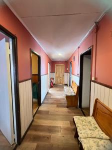 蓬塔阿雷纳斯Casas por día Punta Arenas的一条空的走廊,有橙色的墙壁和木地板