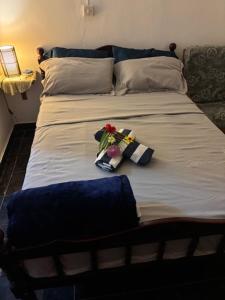 a bed with two pillows and flowers on it at palawan holiday lodge in Port Mathurin