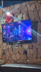 a tv on a wall with a stone wall at Enjoy summer with the family on Camboinha beach in Cabedelo