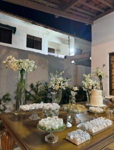 a table with a cake and flowers in vases at Enjoy summer with the family on Camboinha beach in Cabedelo