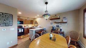 a kitchen with a wooden table and a dining room at Sunrise - W Glade K-5 in Killington