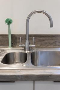 eine Küchenspüle mit Wasserhahn und einem Kaktus in der Unterkunft Elegant & Stylish City Apartment in Bristol + 21 Fotos