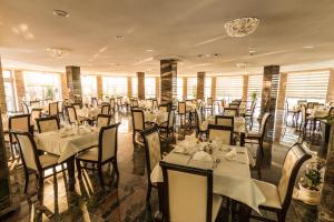 a dining room with tables and chairs with white tablecloths at Miraj Resort in Lučenec