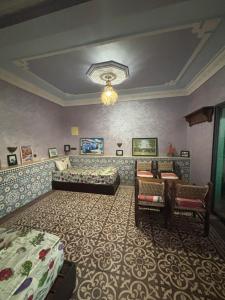 a bedroom with two beds and a couch and a table at Taddart Aglou in Aglou