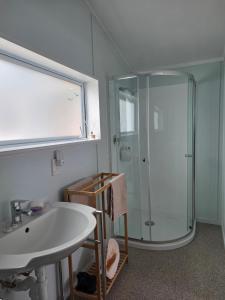 a bathroom with a sink and a shower at Captains Quarters in Ohope Beach