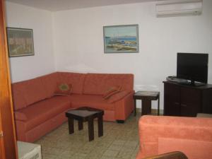 a living room with a couch and a tv at Apartments by the sea Maslinica, Solta - 774 in Grohote