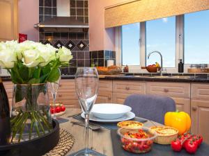 eine Küche mit einem Tisch mit einer Blumenvase in der Unterkunft Frenchgate Cottage in Richmond + 18 Fotos