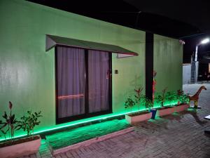 a green building with a window with green lights at Casa Container Natureza Concept in Foz do Iguaçu