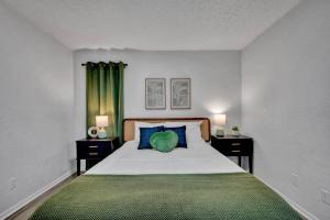 a bedroom with a large bed with blue and green pillows at Near Boone Pickens Stadium - Stillwater Stay in Stillwater