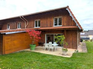 a wooden house with a table and chairs at Gîte au Calme Proche de Nancy avec Terrasse Privative et Parking - FR-1-584-103 in Champenoux