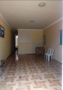 an empty room with two white chairs and a table at Casa das dunas in Prea