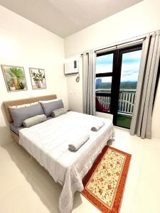 ein Schlafzimmer mit einem großen Bett mit einem großen Fenster in der Unterkunft Peaceful Panglao Escape for Families Couples in Dao