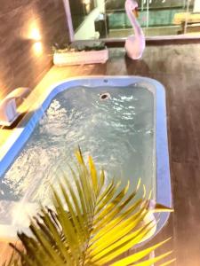 a swimming pool with a palm tree and a pink flamingo at Cobertura com Piscina, Sauna e Churrasqueira in São Pedro da Aldeia