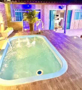 a jacuzzi tub in the middle of a room at Cobertura com Piscina, Sauna e Churrasqueira in São Pedro da Aldeia +31 photos