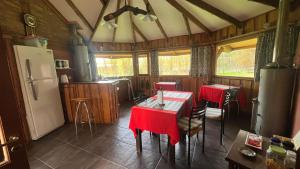 a kitchen with two tables and a refrigerator at Chacra Kaiken Lodge in Perito Moreno