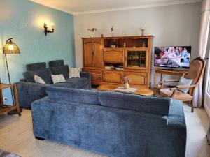a living room with a blue couch and a tv at Maison Indépendante 5 Chambres avec Jardin - Animaux Bienvenus - FR-1-581-75 in Fontenay-sur-Eure