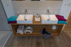 two sinks on a wooden counter in a bathroom at Naturpur Ferienhaus in Friedrichsbrunn +33 photos