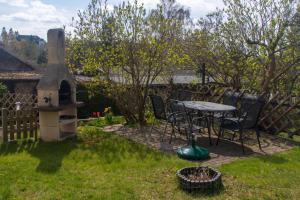a patio with a table and chairs in a yard at Naturpur Ferienhaus in Friedrichsbrunn