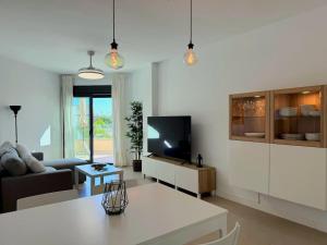 Μια τηλεόραση ή/και κέντρο ψυχαγωγίας στο 1º línea de playa con vistas, piscina & parking