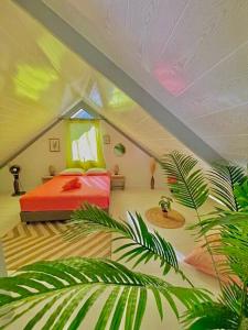 une chambre avec un lit et une chambre avec des plantes dans l'établissement Villa Fare Mananui 2 chambres avec piscine et jardin, à Paea