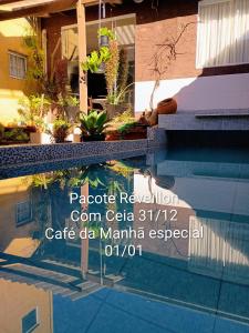 a sign on the side of a swimming pool at Pousada Casa Jardim in Serra Negra