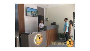 eine Gruppe von Menschen steht an einem Empfangstresen in der Unterkunft One Travelers Place in Koronadal