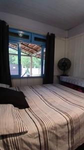a bedroom with a large bed and a window at Cabanas LA CASITA BRISA DO MAR in Navegantes