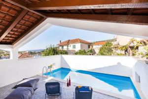 a view of a swimming pool from the balcony of a house at Seaside family friendly house with a swimming pool Drvenik Veliki, Drvenik - 22085 in Veliki Drvenik