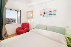 a bedroom with a red heart chair next to a bed at Seaside family friendly house with a swimming pool Drvenik Veliki, Drvenik - 22085 in Veliki Drvenik +25 photos