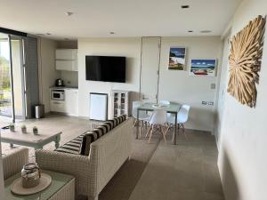 a living room with a couch and a table at Hahei Sunrise in Hahei