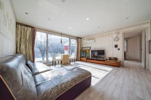 a large living room with a couch and a television at Hue Bless Spa Pension Gapyeong in Gapyeong
