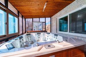 a bathroom with a large white tub with windows at Hue Bless Spa Pension Gapyeong in P'yŏngban-ni