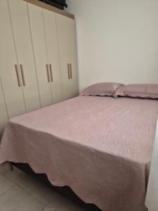 a bedroom with a bed with a pink blanket at Refúgio do Sol in João Pessoa