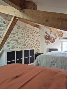 una camera da letto con due letti e un muro di pietra di Naëlo Chartreuse a Biviers