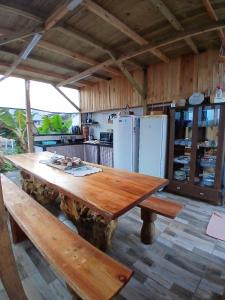 a large wooden table in a kitchen with a refrigerator at Cabanas LA CASITA BRISA DO MAR in Navegantes