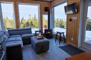 a living room with a couch and a stove at Horizon - plein air et détente in Lac-Beauport