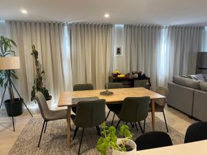 a living room with a table and chairs and a couch at Peaceful house in Kumeu