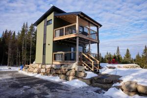 aominium building with a wrap around deck in the snow at Horizon - plein air et détente in Lac-Beauport