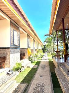 a courtyard of a building with benches and grass at Puspa Guest House Lembongan in Nusa Lembongan