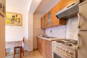 a kitchen with wooden cabinets and a stove top oven at Seaside holiday house Pucisca, Brac - 14003 in Pučišća