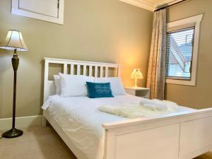 Una cama blanca con almohadas azules y una ventana. en Sakura Stay two bedrooms with a private bathroom, en Richmond