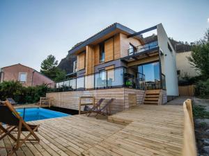 a house with a deck and a swimming pool at Mountain-view eco-friendly cottage in Marcoux
