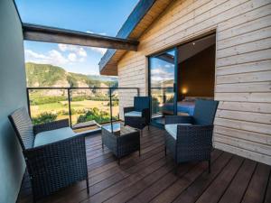 a room with a balcony with chairs and a bed at Mountain-view eco-friendly cottage in Marcoux