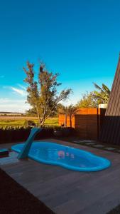 a small swimming pool with a ramp in a yard at Cabanas Farol in Pântano Grande