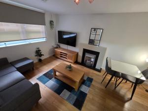 a living room with a couch and a tv at Central Two Bedroom Apartment Near Union Square -Free Parking in Aberdeen